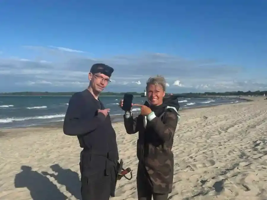 Strandsucher übergibt einer glücklichen Kundin den geborgenen Fund am Ostseestrand